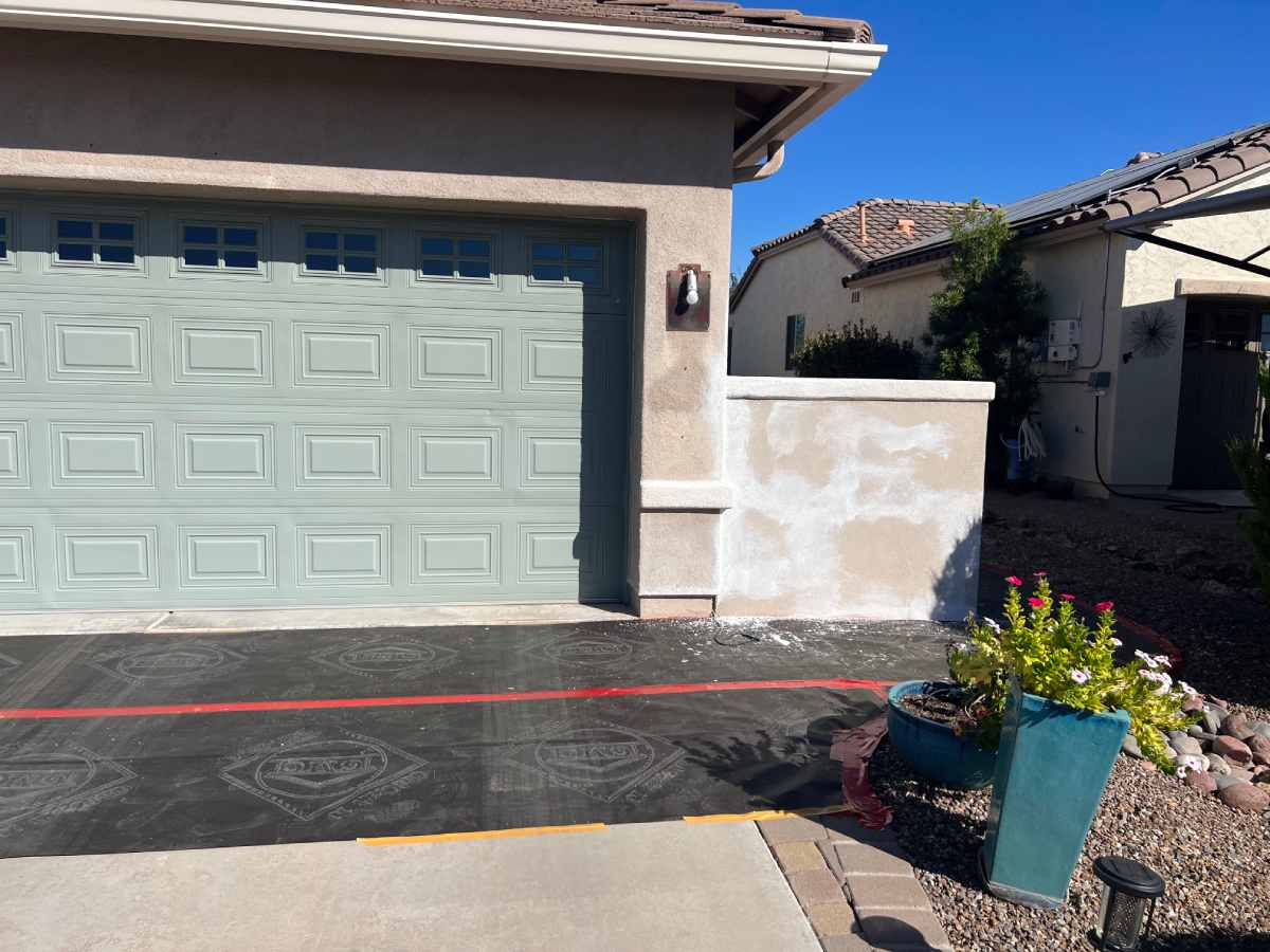 Home exterior undergoing stucco maintenance to repair cracks and wear.